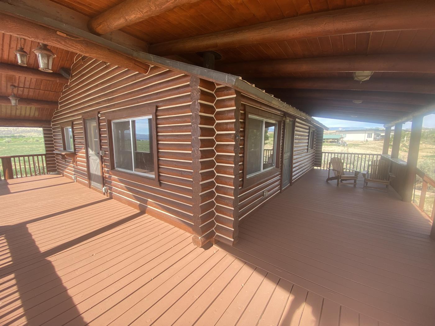 Log home covered deck with fresh stain